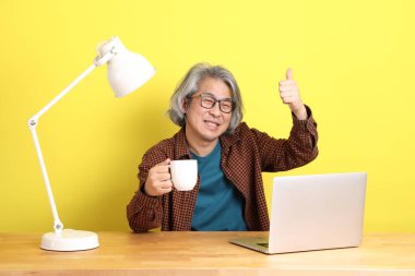 Dizüstü bilgisayarında çalışan renkli bir Asyalı..