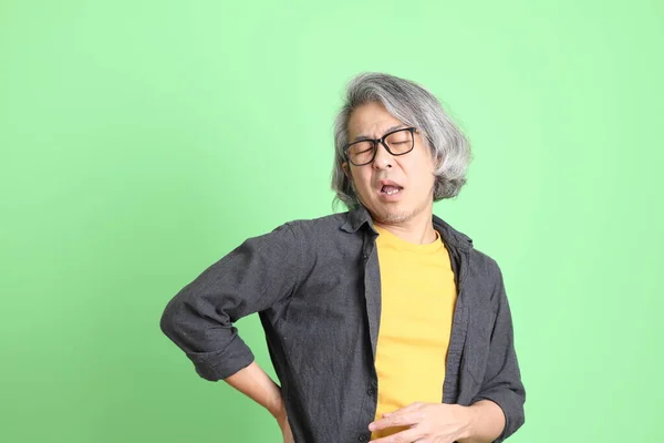 Kıdemli Asyalı Şık Giyinmiş Açık Yeşil Arka Planda Duruyor — Stok fotoğraf