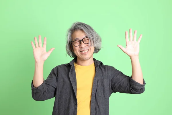 Homem Asiático Sênior Com Casual Inteligente Vestido Contra Fundo Verde — Fotografia de Stock