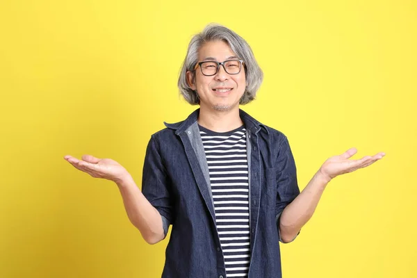 Homem Asiático Sênior Com Jean Vestido Contra Fundo Amarelo — Fotografia de Stock
