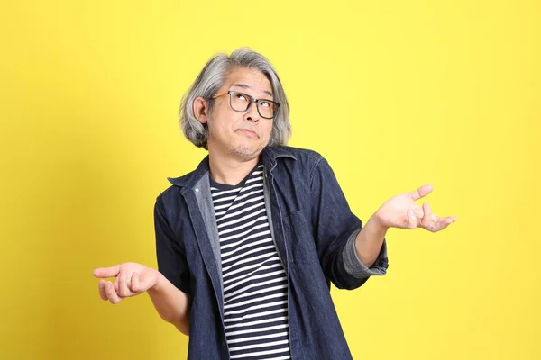 Senior Aziatische Man Met Jean Gekleed Staande Tegen Gele Achtergrond — Stockfoto