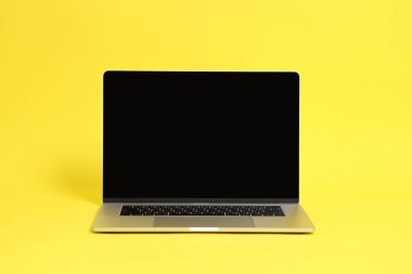 Sarı arkaplandaki gümüş dizüstü bilgisayar ayarı.