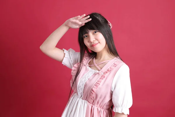日本の可愛い衣装を着た10代のアジアの女の子が赤い背景に立って — ストック写真