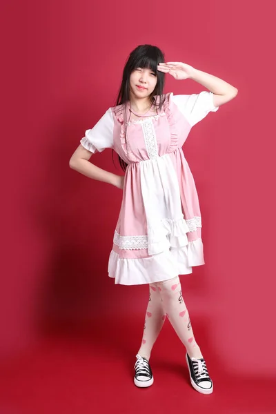 日本の可愛い衣装を着た10代のアジアの女の子が赤い背景に立って — ストック写真