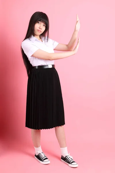 Das Asiatische Mädchen Mit Uniform Steht Auf Dem Rosa Hintergrund — Stockfoto