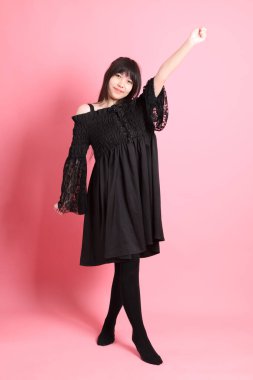 Pembe arka planda gotik giyinmiş yakışıklı Asyalı kız.