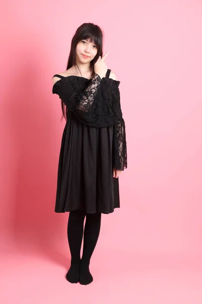 Pembe arka planda gotik giyinmiş yakışıklı Asyalı kız.