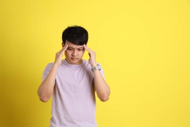 Sarı arka planda duran Asyalı genç adam..