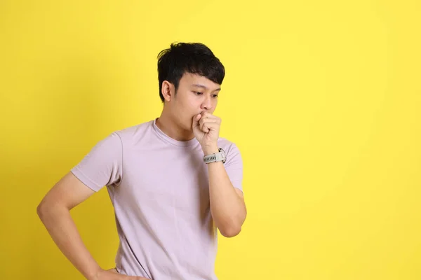 黄色の背景に立つ若い大人のアジア人男性 — ストック写真