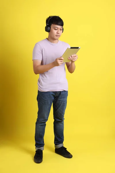 Νεαρός Ενήλικας Ασιάτης Που Στέκεται Στο Κίτρινο Φόντο — Φωτογραφία Αρχείου