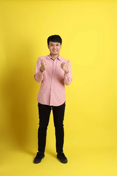 Der Asiatische Mann Mit Rosa Hemd Steht Auf Gelbem Hintergrund — Stockfoto