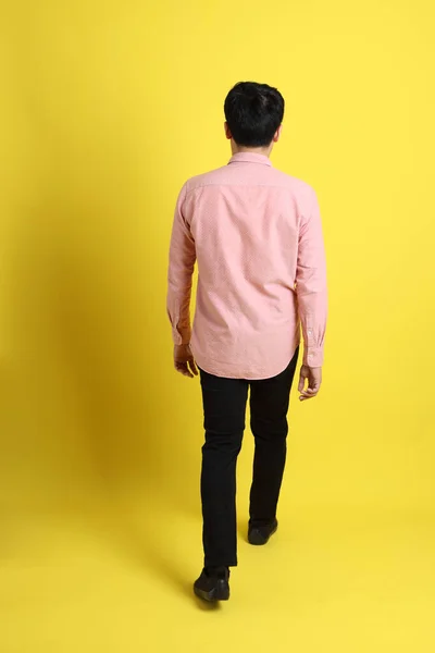 Азіат Рожевою Сорочкою Стоїть Жовтому Фоні — стокове фото