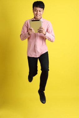 Sarı arka planda duran Asyalı genç adam..