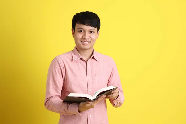 黄色の背景に立つ若い大人のアジア人男性 — ストック写真