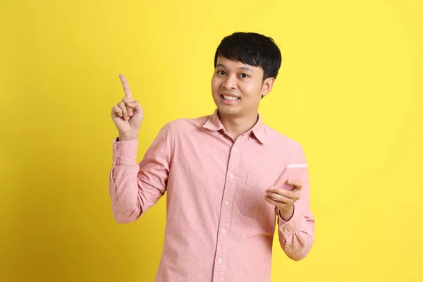 Sarı Arka Planda Duran Asyalı Genç Adam — Stok fotoğraf