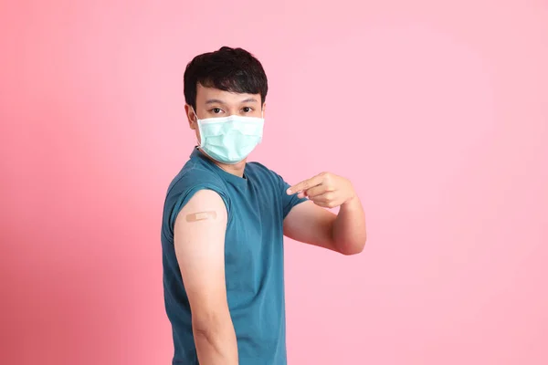 Mladý Dospělý Asiat Stojí Růžovém Pozadí Ochranné Masce Obvazem Paži — Stock fotografie