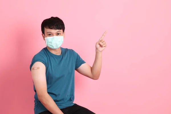 Mladý Dospělý Asiat Stojí Růžovém Pozadí Ochranné Masce Obvazem Paži — Stock fotografie