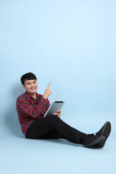 Young Adult Asian Man Sitting Blue Background — Stock Photo, Image