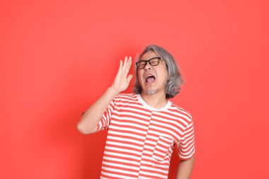 Turuncu arka planda günlük giysileri olan kıdemli Asyalı adam..