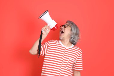 Turuncu arka planda günlük giysileri olan kıdemli Asyalı adam..