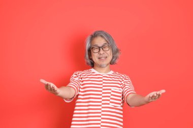 Turuncu arka planda günlük giysileri olan kıdemli Asyalı adam..