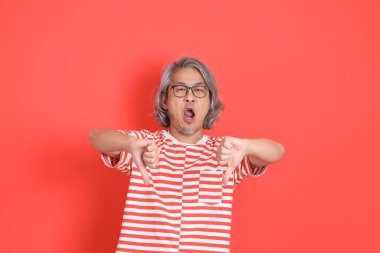 Turuncu arka planda günlük giysileri olan kıdemli Asyalı adam..