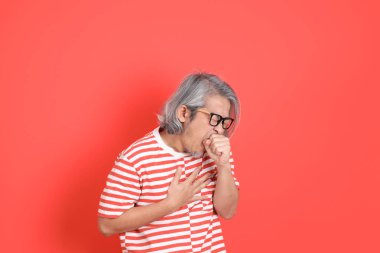 Turuncu arka planda günlük giysileri olan kıdemli Asyalı adam..