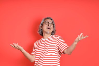 Turuncu arka planda günlük giysileri olan kıdemli Asyalı adam..