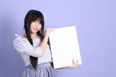 Mor arka planda duran mor giysili Asyalı genç kız..