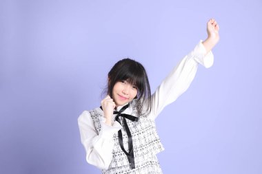 Mor arka planda duran beyaz elbiseli Asyalı genç kız..