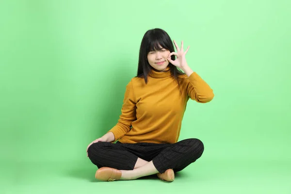Молода Дівчина Азії Випадковому Одязі Сидить Зеленому Фоні — стокове фото