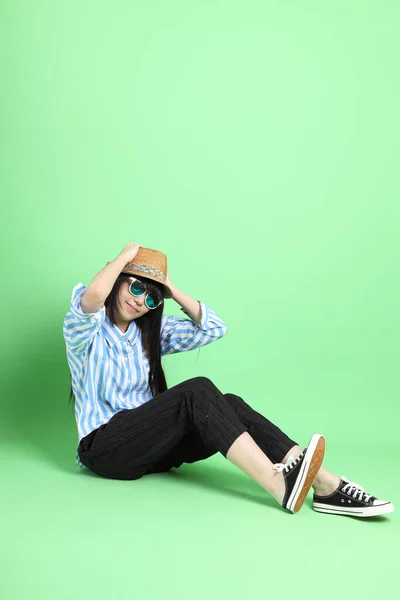 Yeşil Arka Planda Oturan Sıradan Giyinmiş Asyalı Genç Kız — Stok fotoğraf