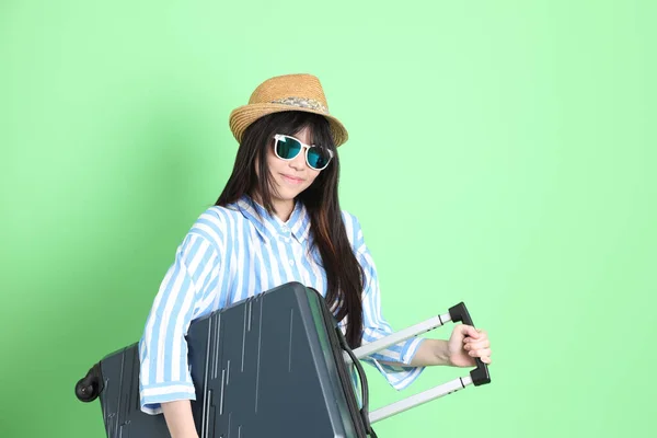 荷物と緑の背景に立ってカジュアルに身を包んだ若いアジアの女の子 — ストック写真