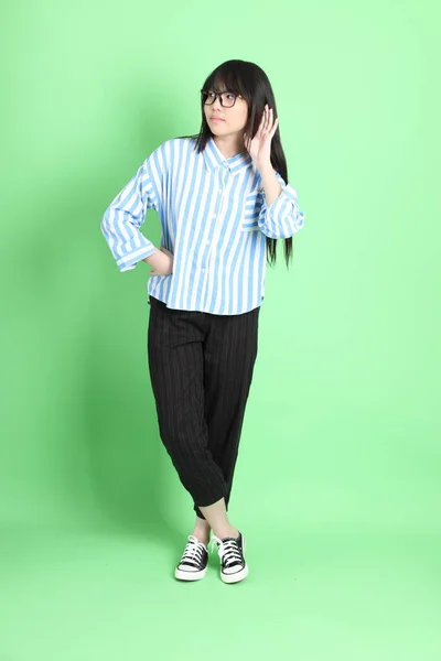 Yeşil Arka Planda Sıradan Giyinmiş Genç Asyalı Kız — Stok fotoğraf