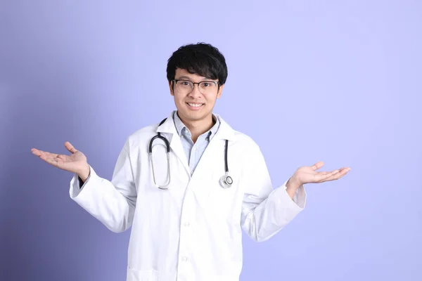 Młody Dorosły Azjatycki Lekarz Stojący Fioletowym Tle — Zdjęcie stockowe