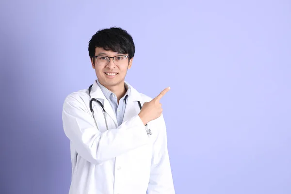 Молодий Азіатський Лікар Який Стоїть Пурпуровому Фоні — стокове фото