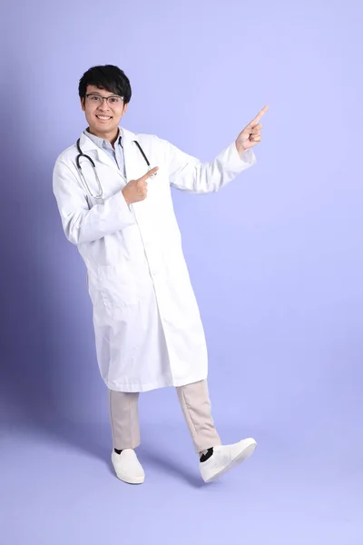 Joven Adulto Médico Asiático Pie Sobre Fondo Púrpura —  Fotos de Stock