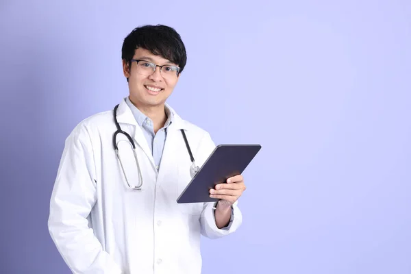 Młody Dorosły Azjatycki Lekarz Stojący Fioletowym Tle — Zdjęcie stockowe