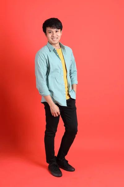 Young Adult Southeast Asian Man Green Shirt Standing Orange Background — ストック写真