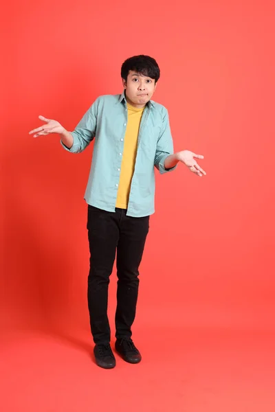 Young Adult Southeast Asian Man Green Shirt Standing Orange Background — ストック写真