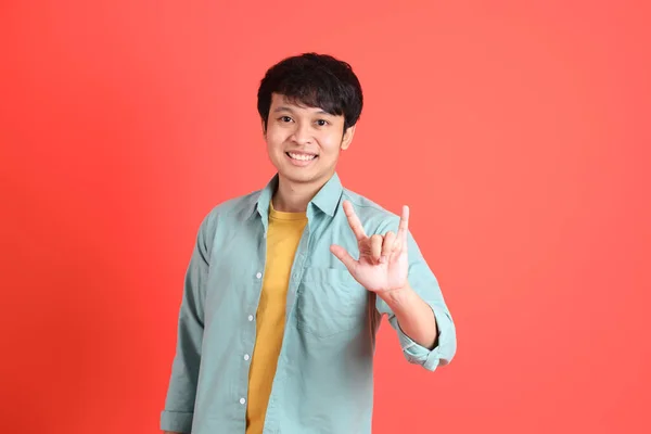 Молодий Чоловік Південно Східної Азії Зеленою Сорочкою Оранжевому Фоні — стокове фото