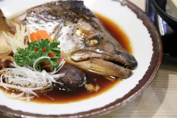 Soya çorbasında kaynatılmış somon balığı kafası mantar ve havuçla servis edilir..