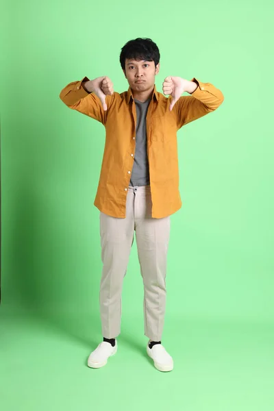 若いです大人アジアの男とともにスマートなカジュアル服上のライトグリーンの背景 — ストック写真