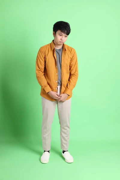 若いです大人アジアの男とともにスマートなカジュアル服上のライトグリーンの背景 — ストック写真