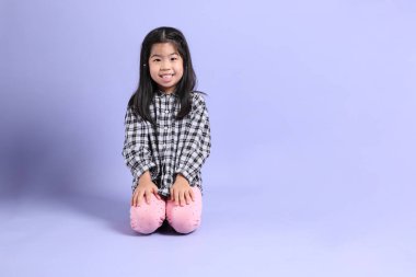 Mor arka planda oturan genç Asyalı ızgara..