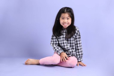 Mor arka planda oturan genç Asyalı ızgara..