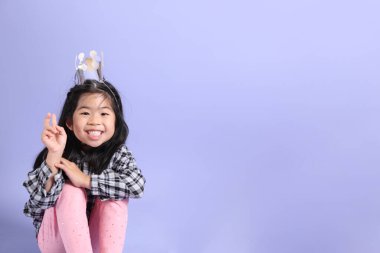 Mor arka planda duran genç Asyalı ızgara..