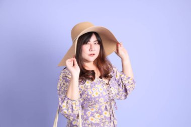 Mor arka planda sıradan kıyafetlerle duran tombul Asyalı kadın..