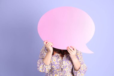 Mor arka planda sıradan kıyafetlerle duran tombul Asyalı kadın..