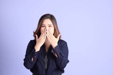 Mor arka planda sıradan kıyafetlerle duran tombul Asyalı kadın..